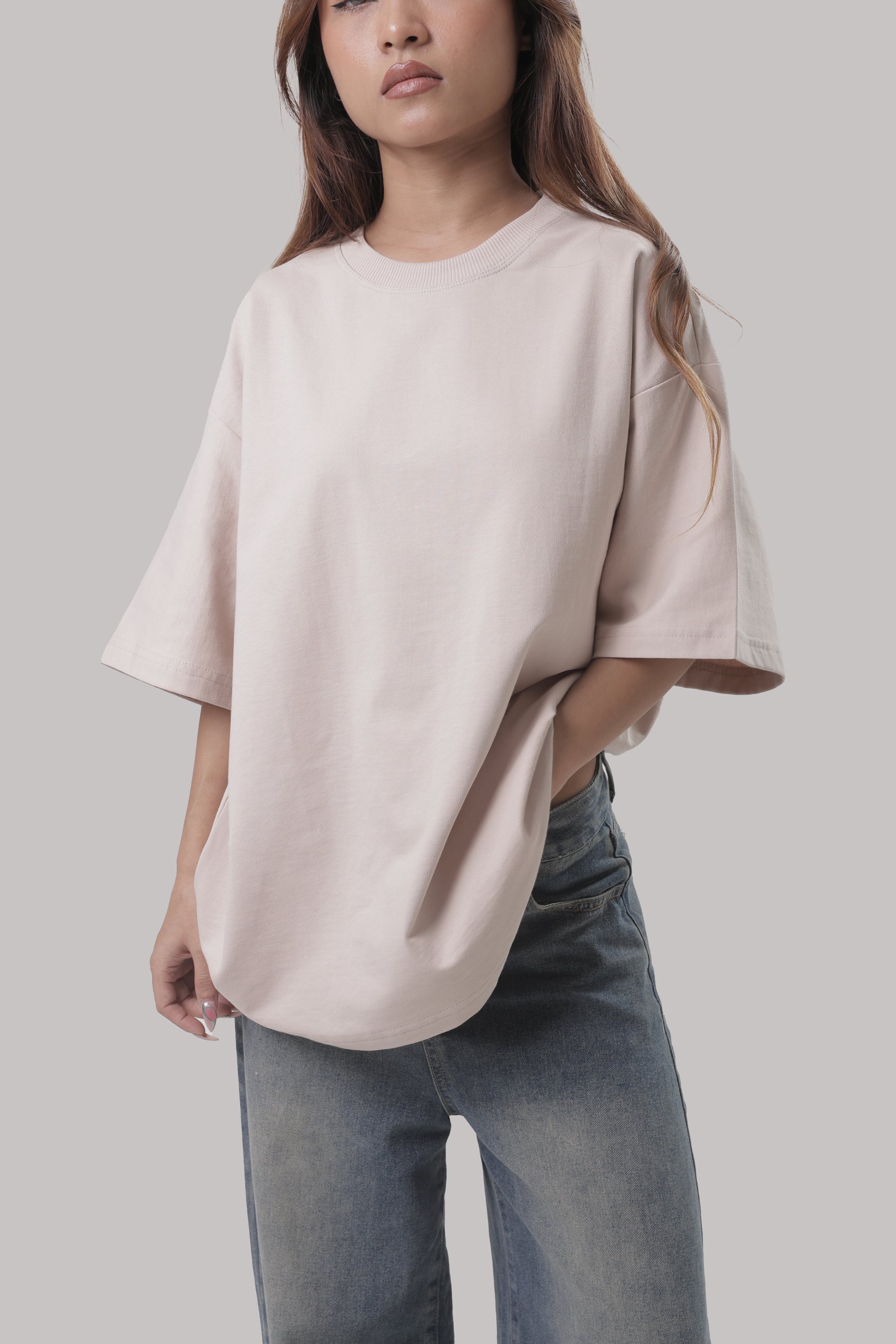 Female model wearing YuloLife solid beige oversized cotton terry 240 GSM tee, front view showcasing relaxed unisex fit